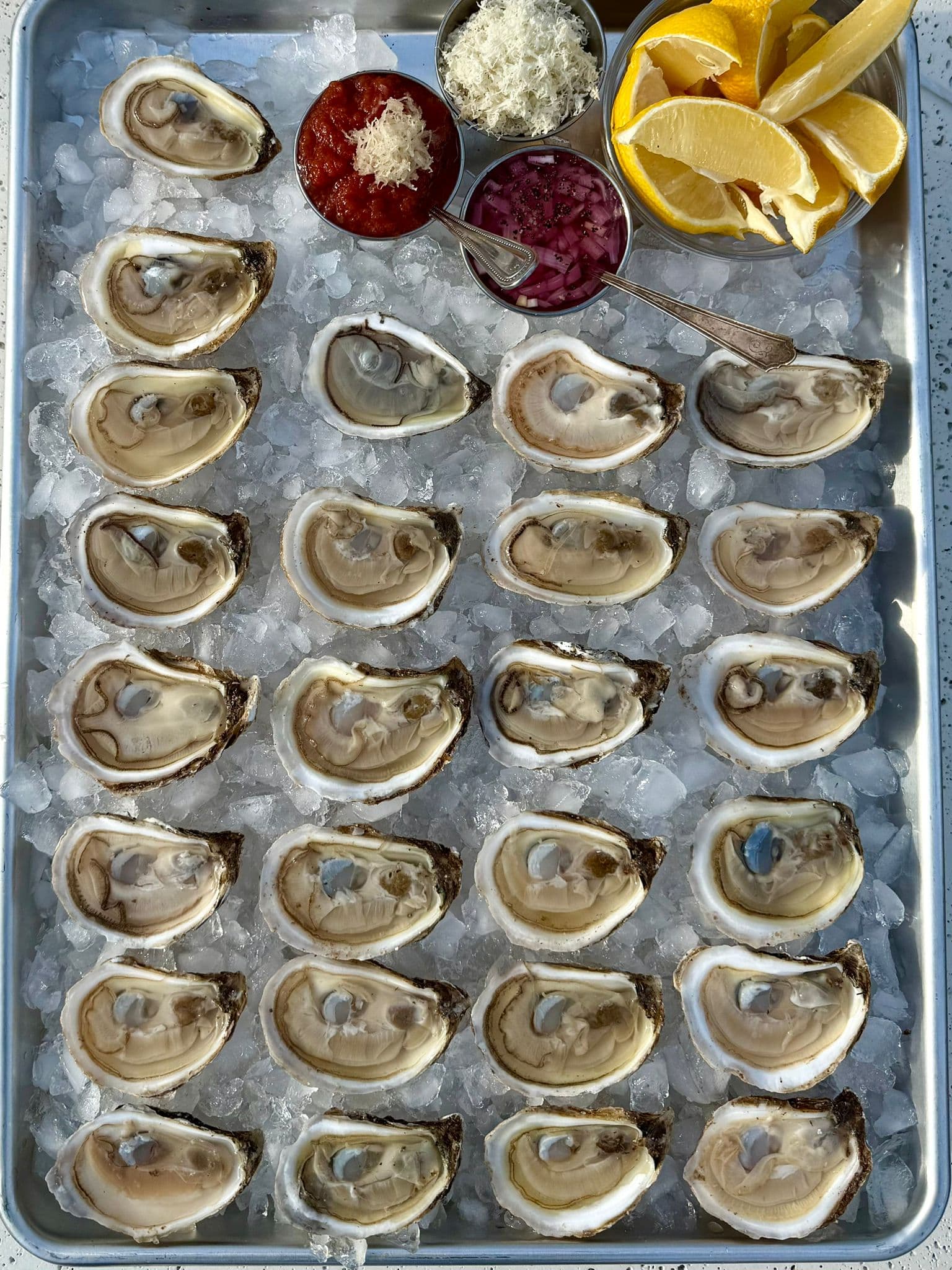 Fresh oysters with lemons, mignonette, and cocktail sauce.