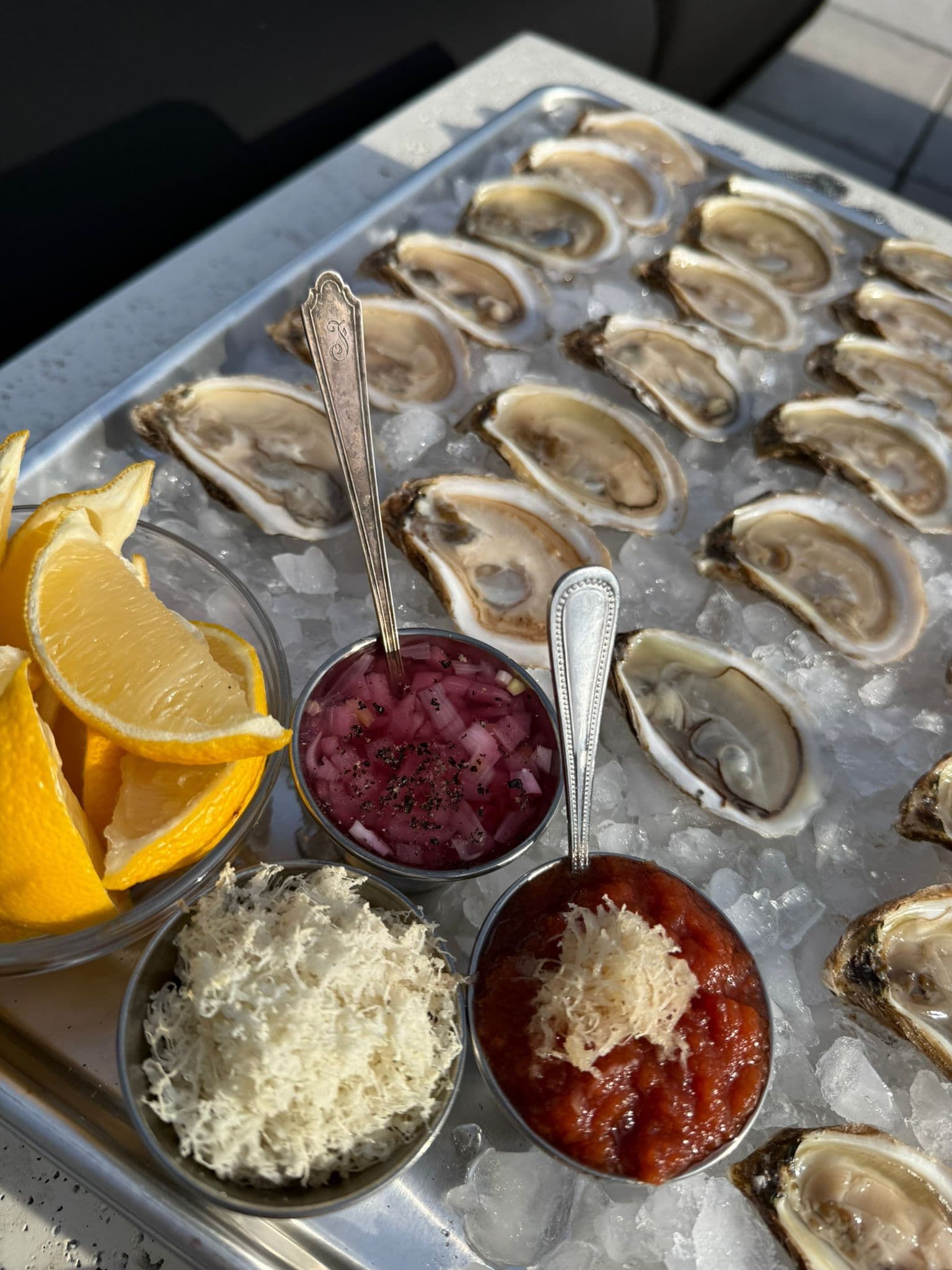 Shucked oysters with condiments arranged for service.